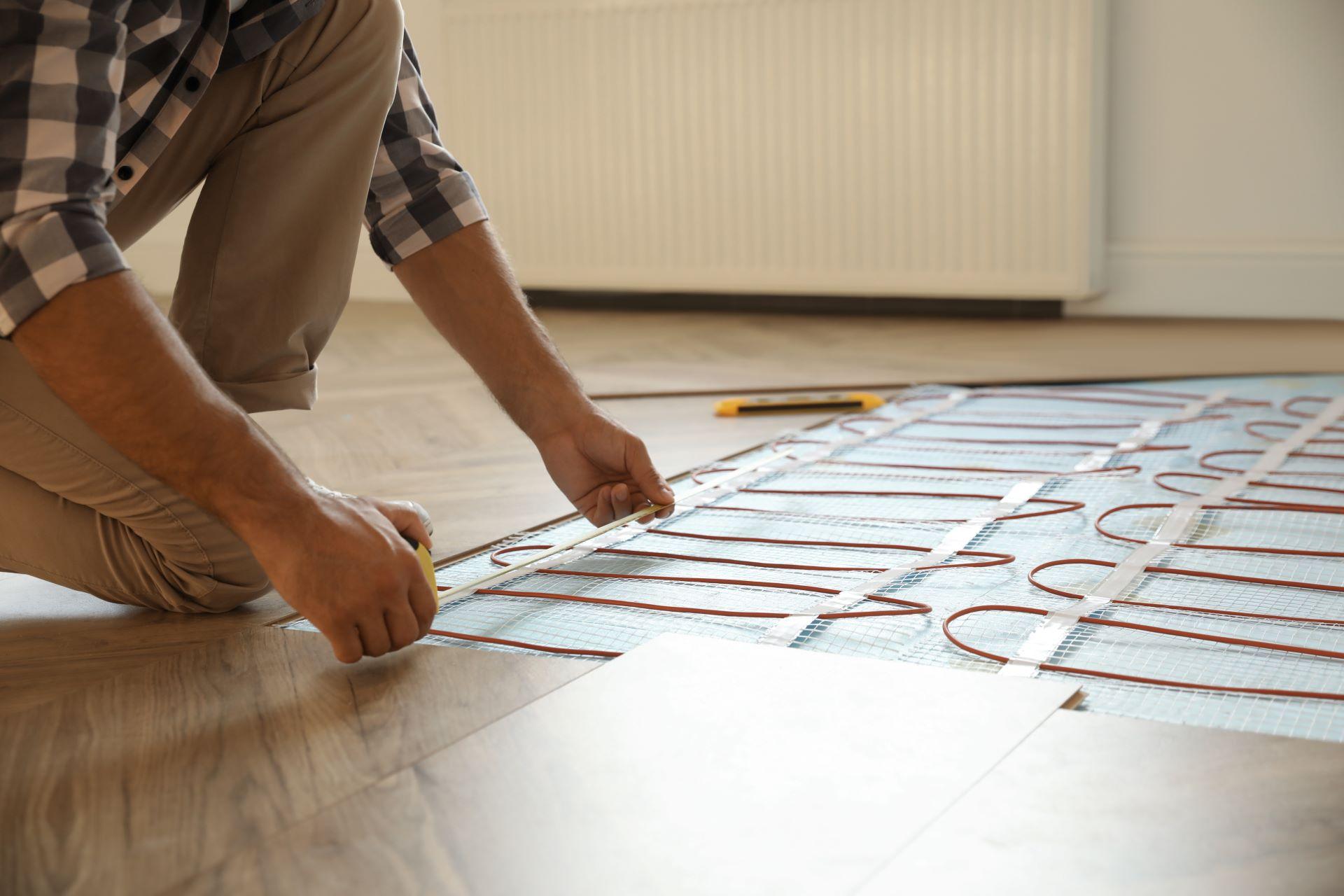 Handwerker bei der Installation einer Fußbodenheizung